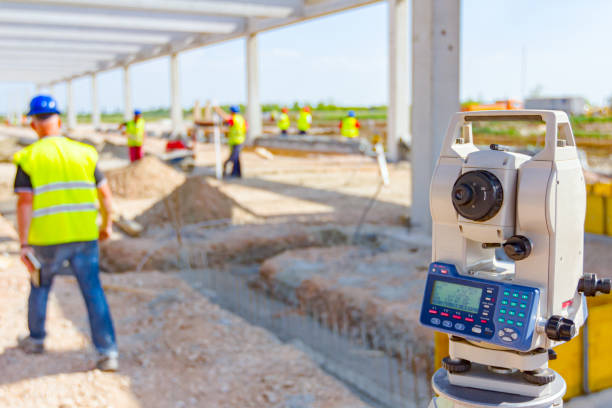 A man holding a shovel stands before a building, illustrating the concept of material testing for earthworks.